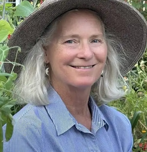 Linda Ziedrich, author of First Fruits, in a sun hat in her garden