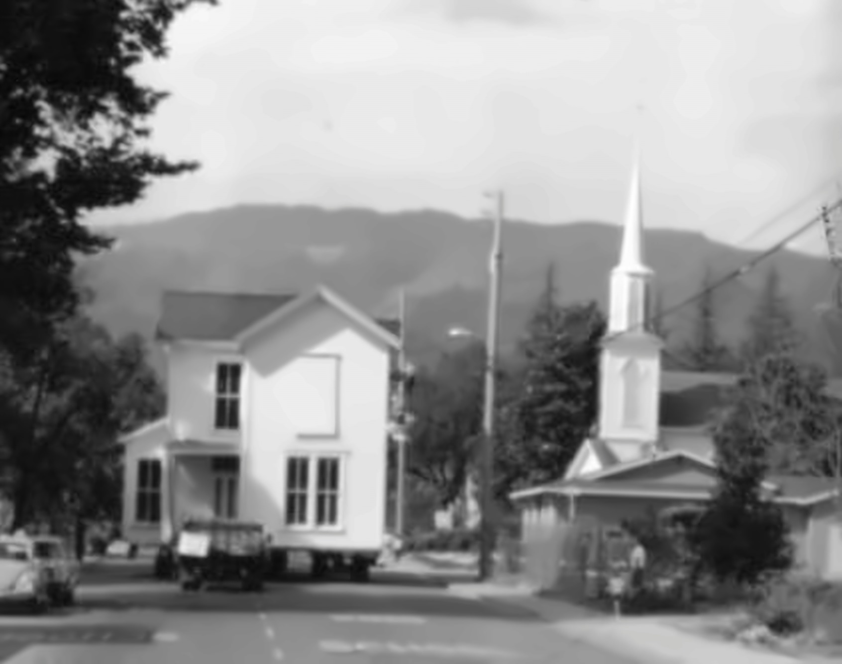 Historic St. Helena street scene — a house being moved past the church (St. Helena Historical Society collection)