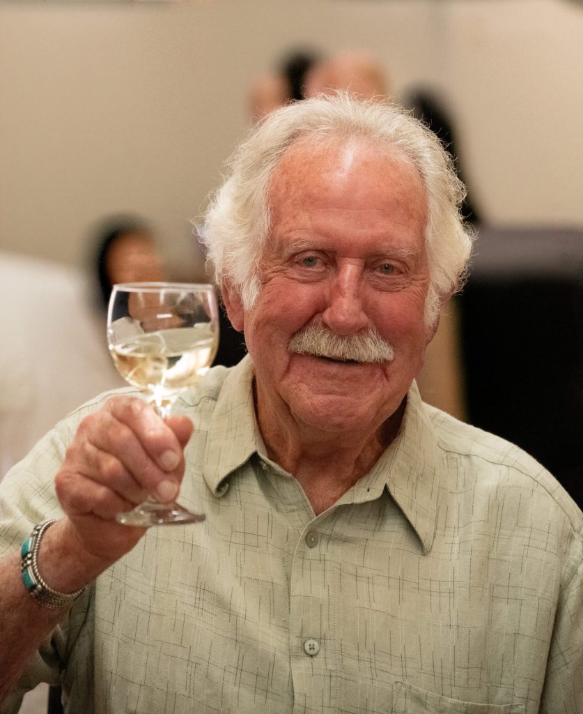 A guest raises a glass of white wine.