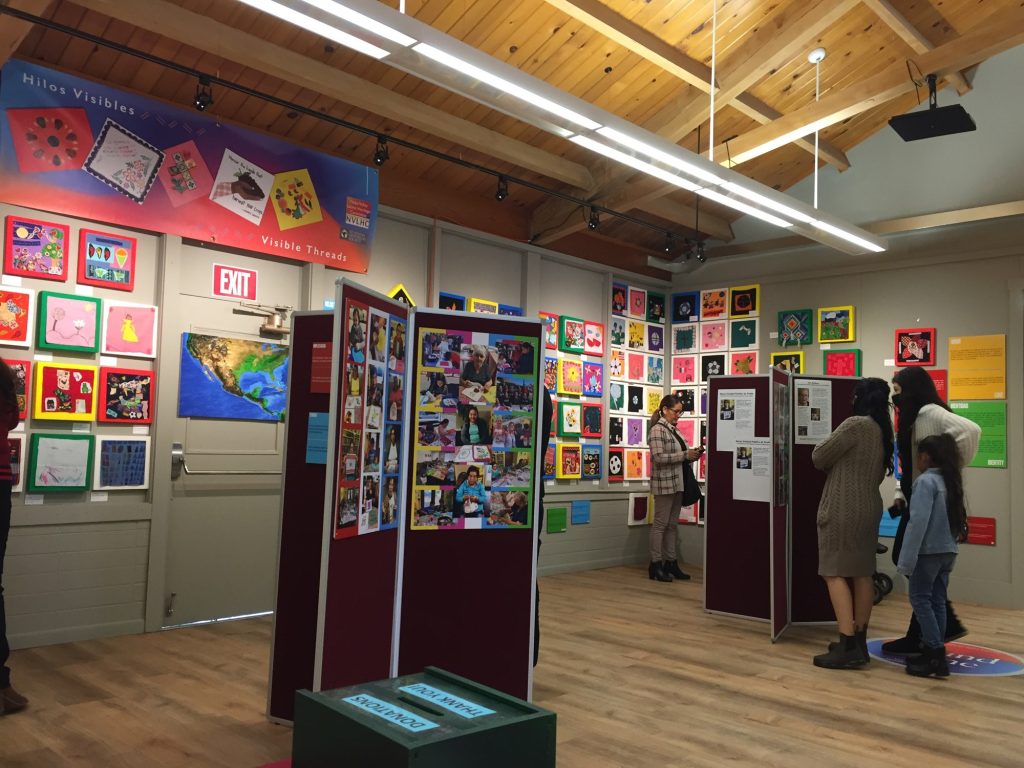 Quilt squares and photo panels in the Hilos Visibles (Visible Threads) exhibit at the St. Helena Historical Society, 2022